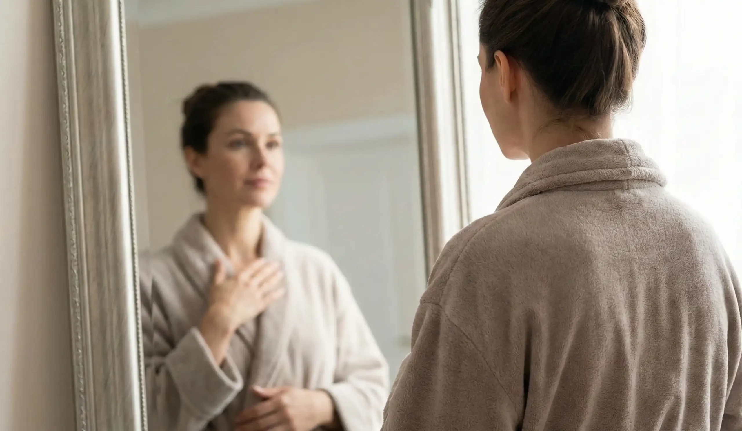 woman looking in mirror contemplating