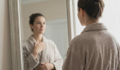 woman looking in mirror contemplating