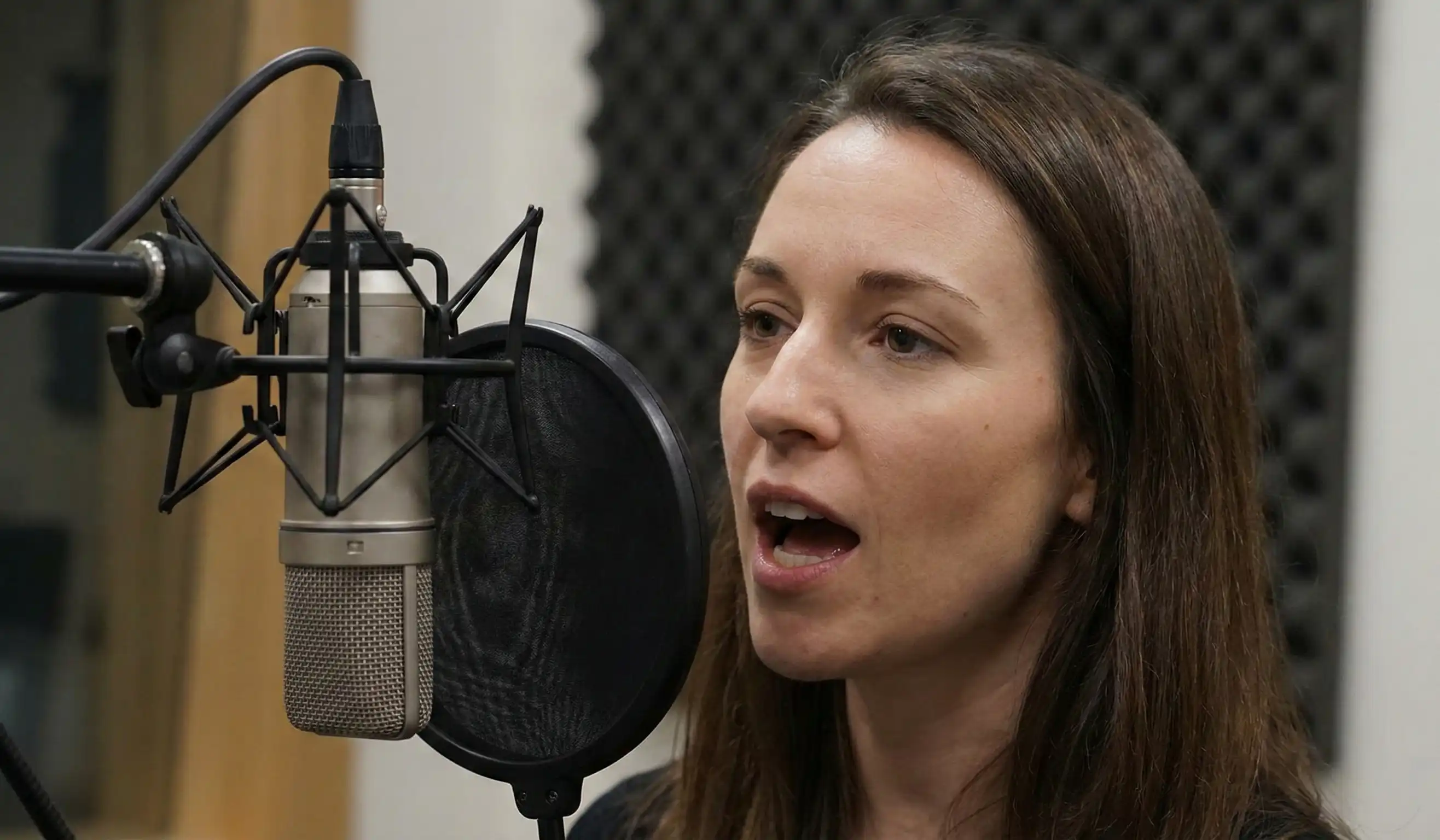woman speaking into microphone recording studio