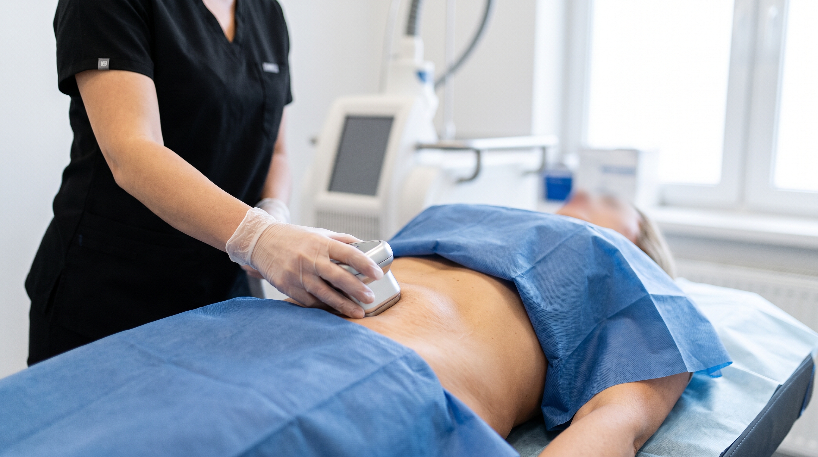 Patient receiving a non-invasive body contouring procedure for subtle fat removal and skin tightening.