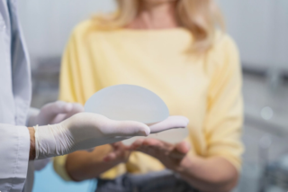 doctor holds a breast implant