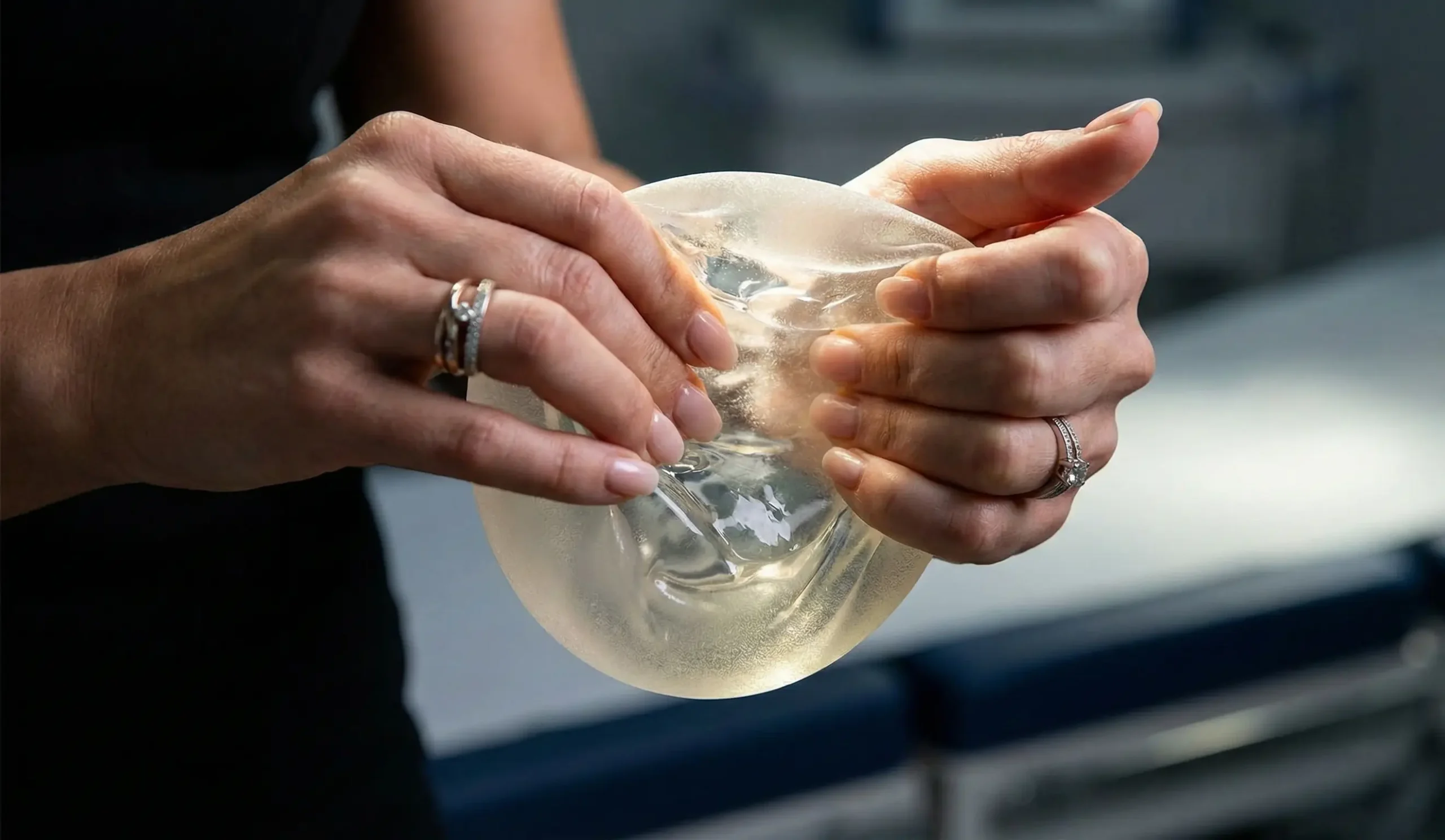 hands firmly squeezing and twisting silicone implant