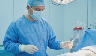 liposuction surgeon in operating room holding cannula