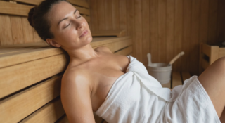 woman with breast implants relaxing in sauna